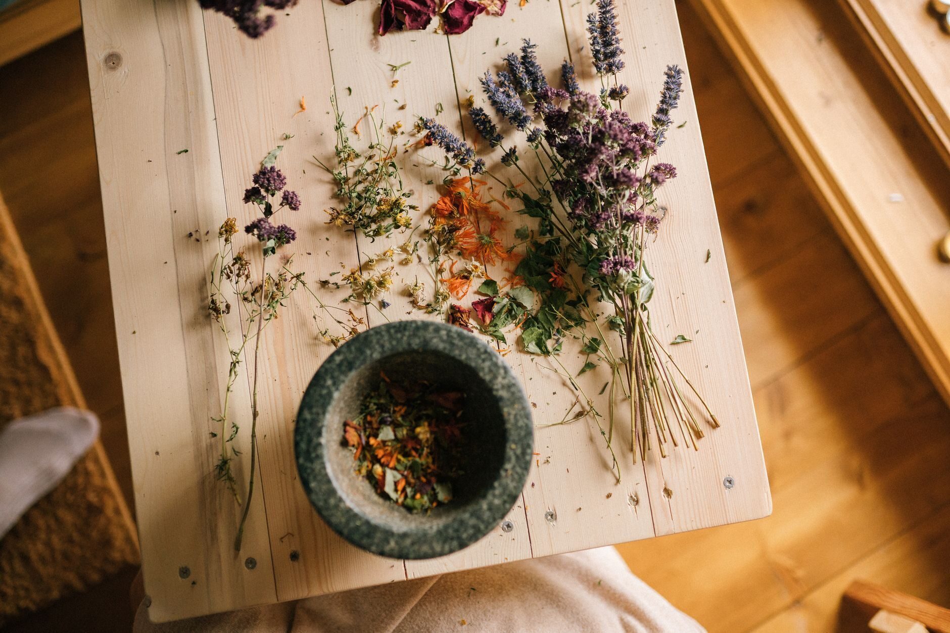 Overhead still life of a mortar with lavender and chamomile bundles