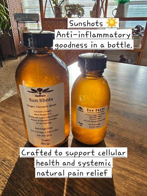 Two amber bottles of RedFern Sun Shots turmeric-ginger extract on a wooden table